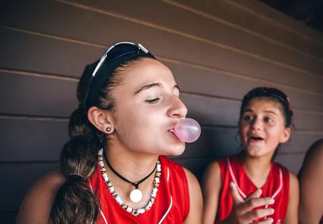 A child blowing a bubble with bubble gum