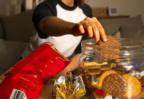 woman snacking on lots of chips and cookies