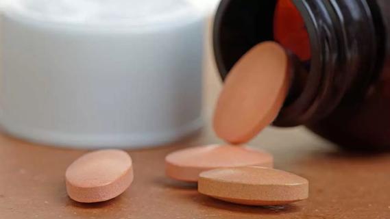 close up of bottle of pills spilling onto table