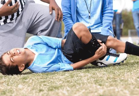 Soccer player on ground with ankle pain