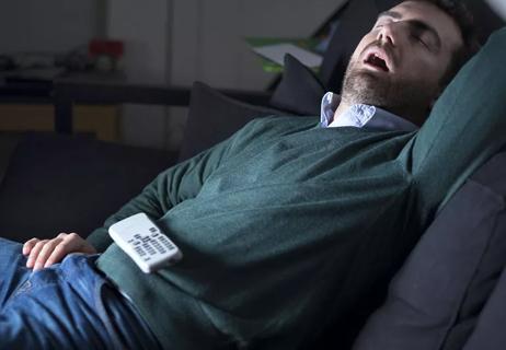 Overweight man with diabetes snoring in front of TV