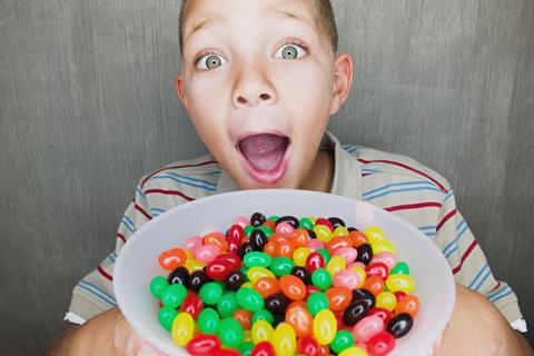 Child holding bowl of jellybeans