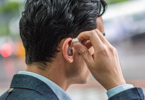 Man fixing hearing aid