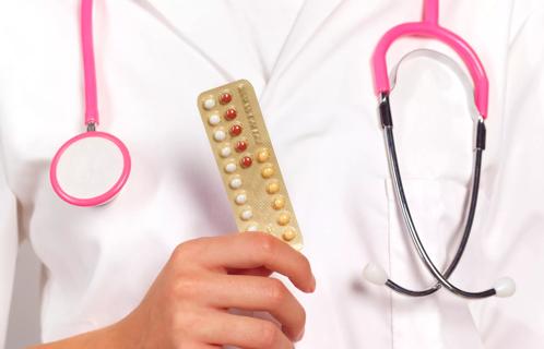 Healthcare provider holding packet of birth control pills