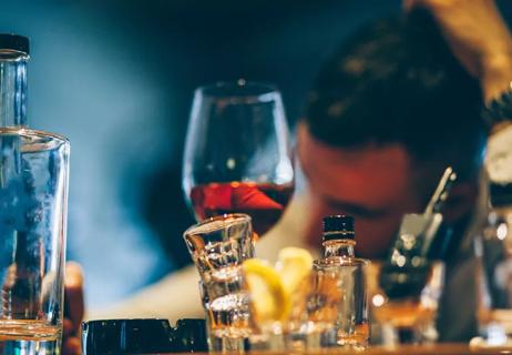 Man drunk with consumed bottles in front