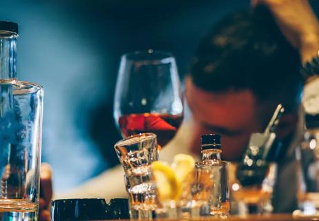 Man drunk with consumed bottles in front