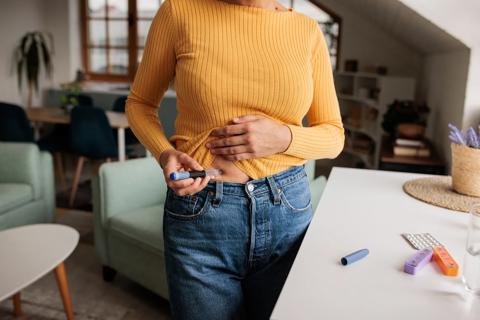 Woman injecting fertility medication into stomach area