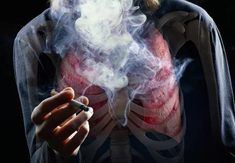 Young man smoking cigarette, face obscured by smoke
