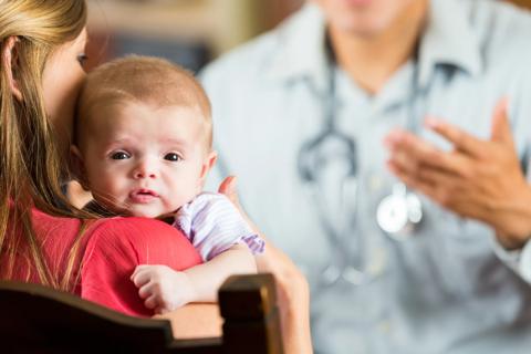 Mom holds baby while talking with clinician