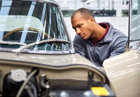 man examining classic car