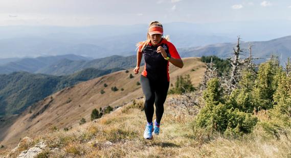 Person running up rugged terrain on mountain trail