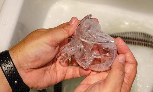 Hands cleaning parts of a CPAP in soapy water