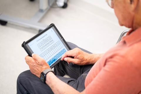 older man taking cognitive test on computer tablet