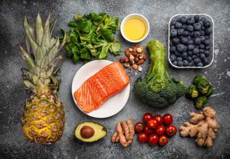 Assorted anti-inflammatory foods, including fish, veggies, fruits, nuts and oil