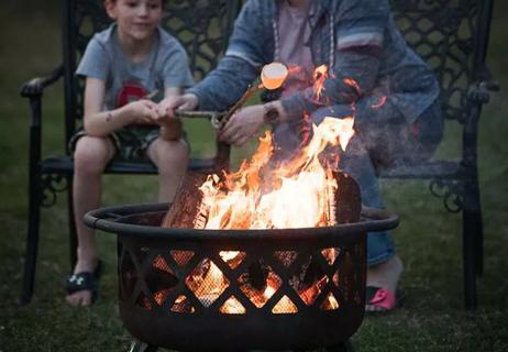 family roasting marshmallows around firepit