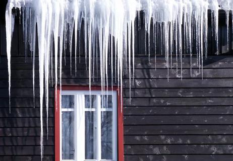 Dangerous icicles above window on house
