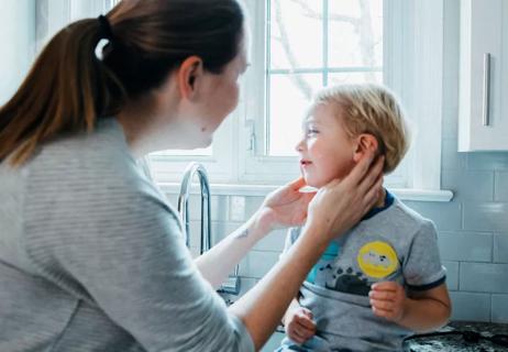 Mom checking on son's earache at home