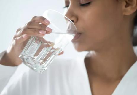 A person drinking a glass of water