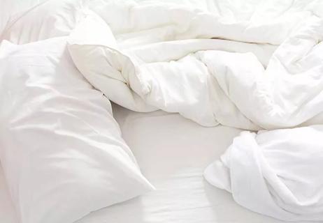 fixed pillows on a messy bed with towel