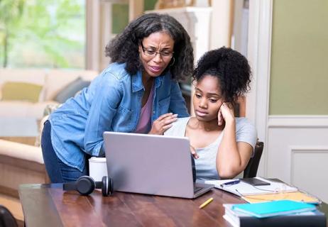 Mom and daughter looking at school test score on computer