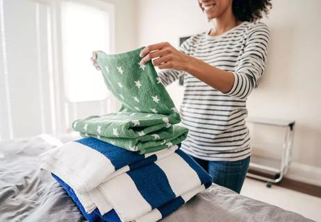 person standing and folding towels