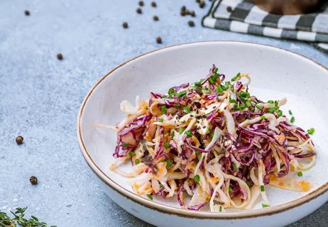 Chia cole slaw in a white bowl on a light background.