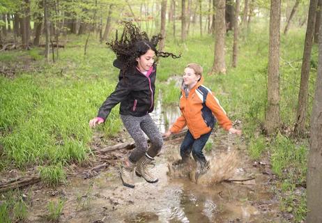 kids jumping in stream at park