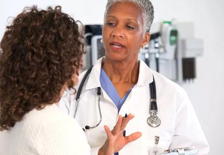 Woman discusses options of care with her doctor at her appointment.
