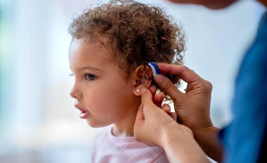 Child being fitted with a hearing aid