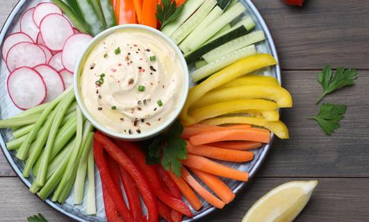 Veggie tray with cream cheese dip in center of tray