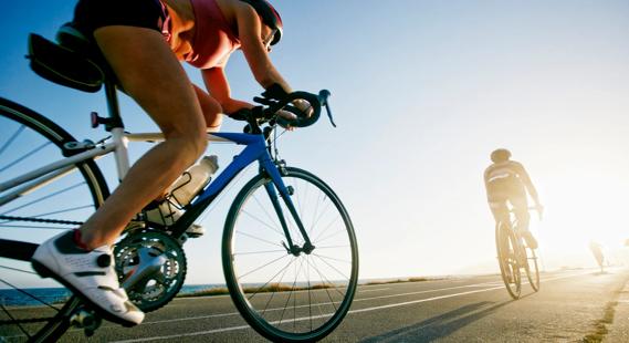 Competition cyclists riding in line on paved road