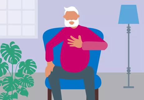 elderly person sitting in an armchair with hand on his chest