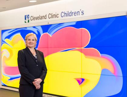 Physician Karen Murray stands in front of Cleveland Clinic Children's signage