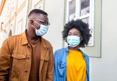 Couple wearing face masks walking down street