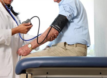 Physician taking a man's blood pressure.