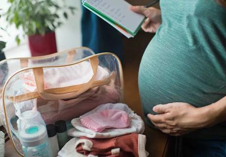 Pregnant woman prepping overnight bag for birth.