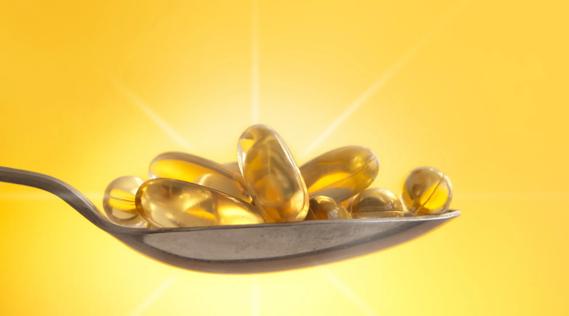 Vitamin D capsules backlit by sunlight