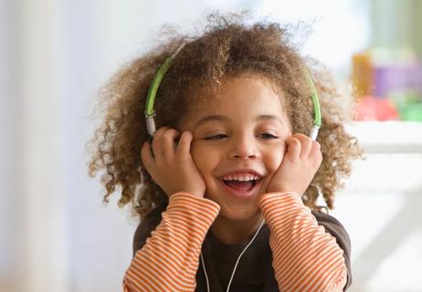 child listening to music while wearing headphones