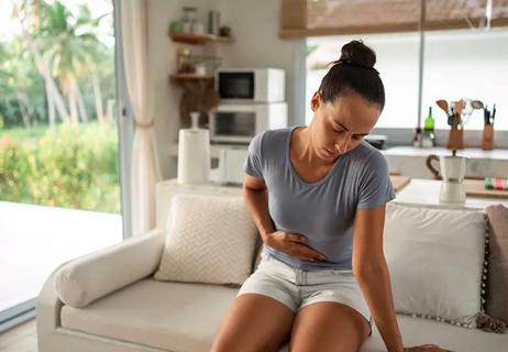 woman holding lower abdomen in discomfort