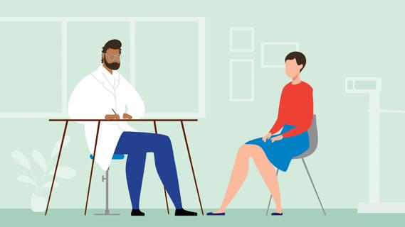 Person sitting in chair across from healthcare professional at a desk in medical office