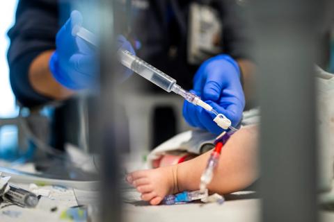 Nurse examines infant's central line