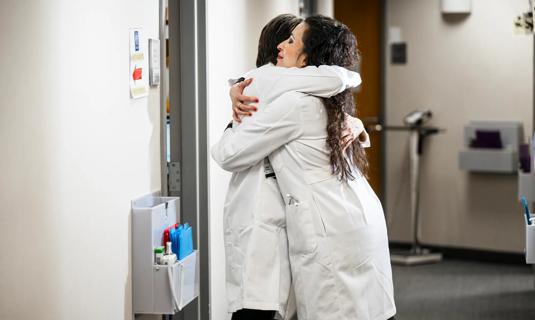 Two physicians hugging