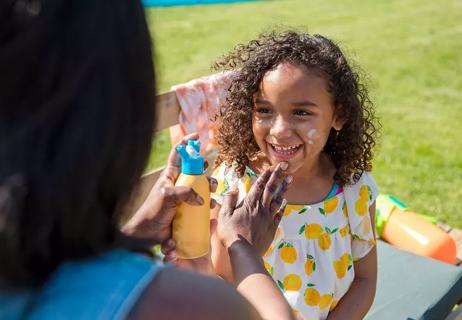 mom applies sunscreen to child