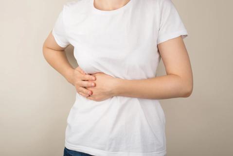 Person holding their side, where their gallbladder is