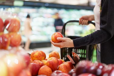 Person picking out apples at grocery store