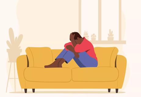 An illustration of a person sitting on a couch with their head in their hands