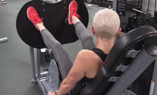 Woman using leg press machine
