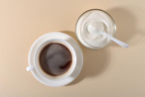 Cup of coffee and bowl of collagen peptide powder with spoon