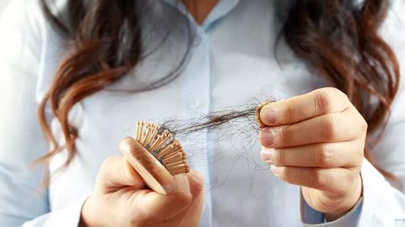 close up of female pulling hairs from a brush