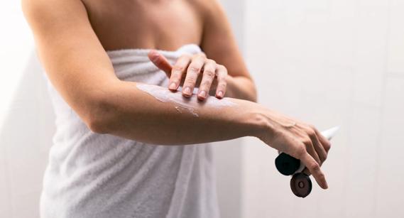 Person applying lotion after a shower